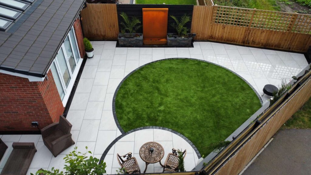 Aerial view of a circular lawn, porcelain patio and corten water feature