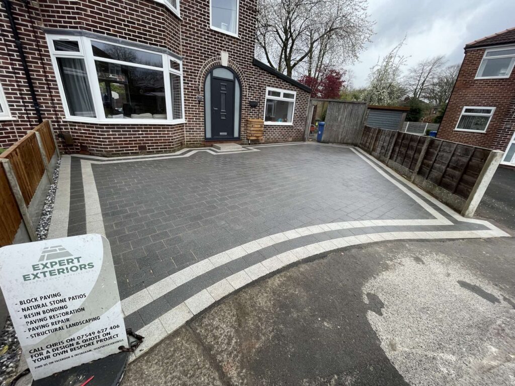 Charcoal block paving driveway with an Expert Exteriors sign