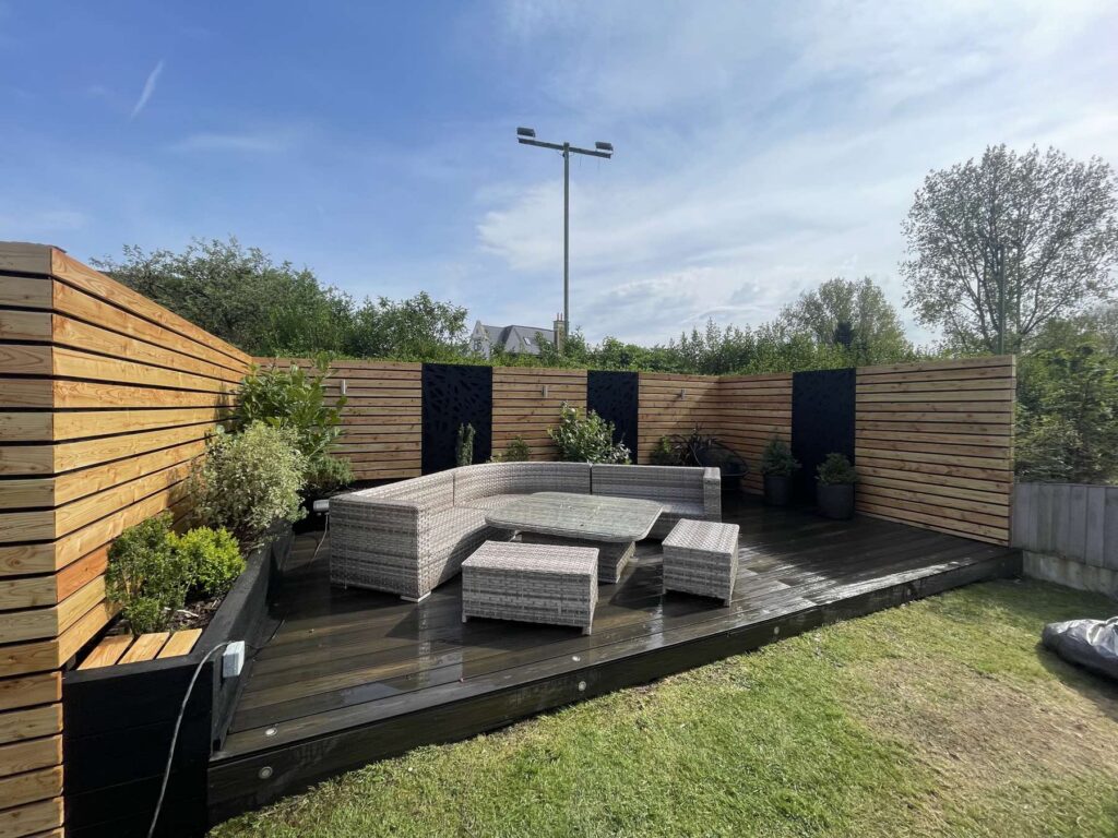 Composite decking with slatted fencing and outdoor sofa
