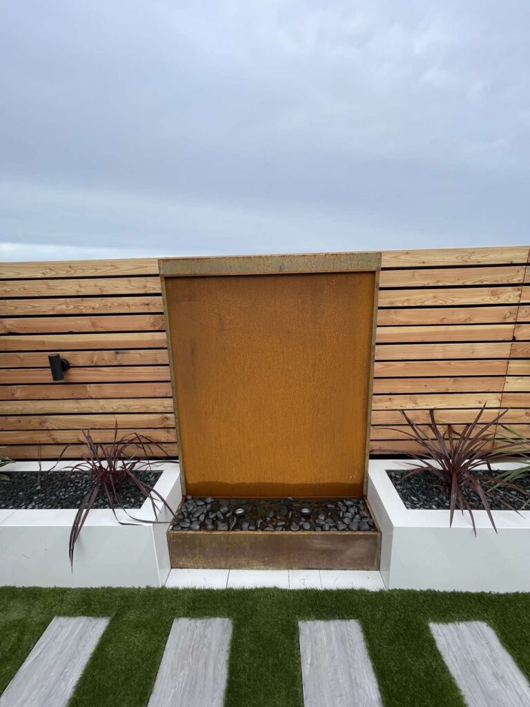 Corten steel water feature between raised planters