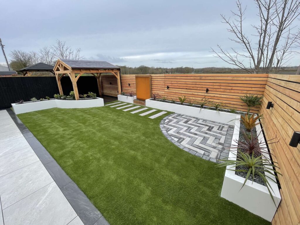 Landscaped garden with an oak gazebo, raised planters and herringbone paving