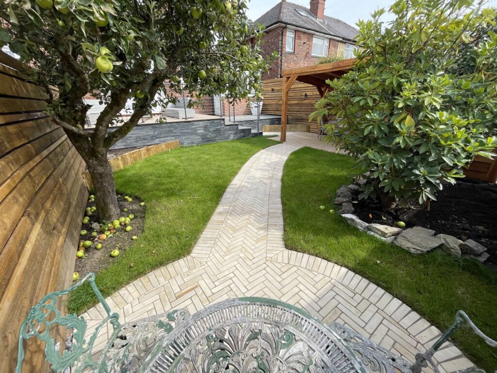 Herringbone paved path curving through a lawn