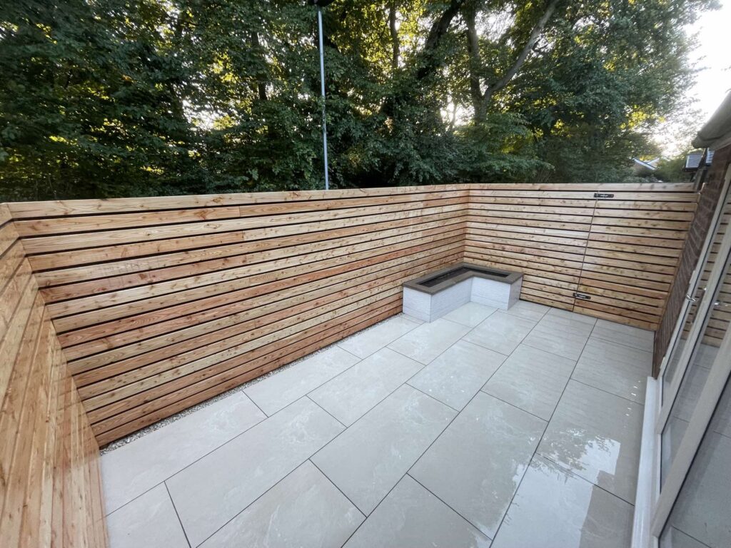 Porcelain courtyard enclosed by a slatted timber fence