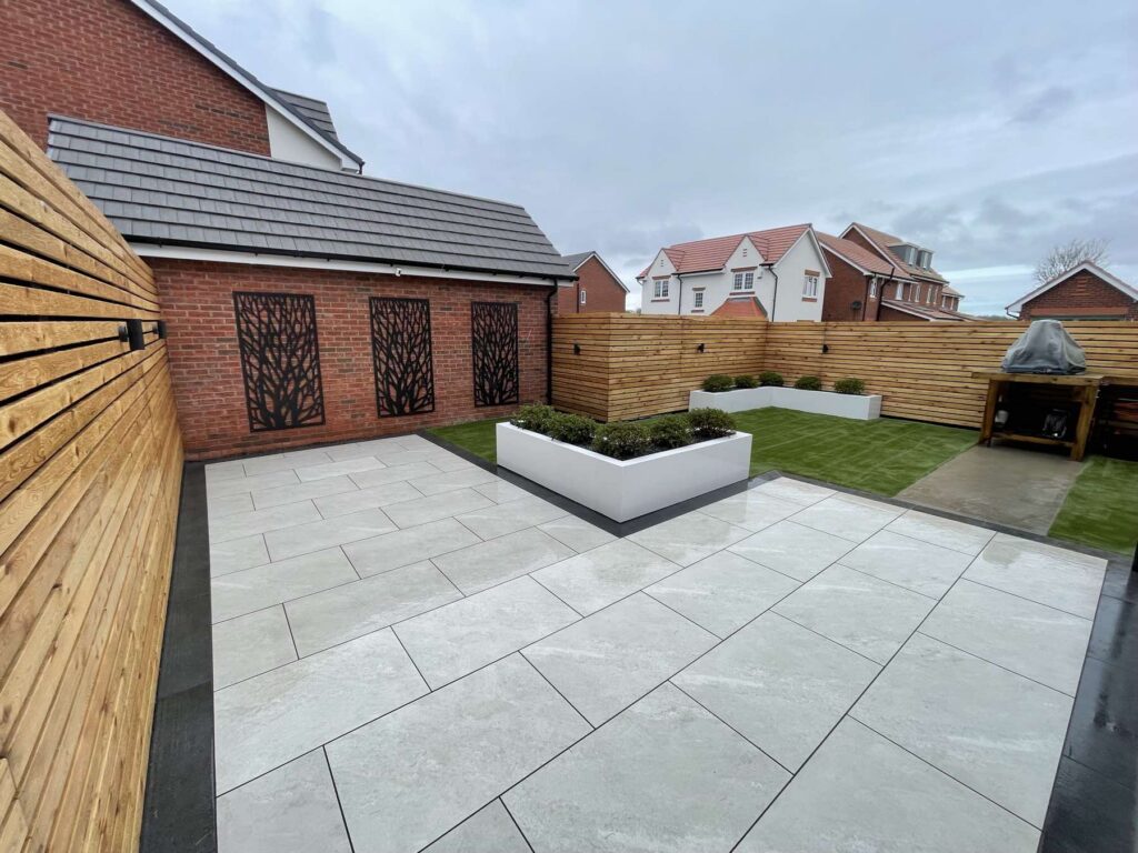 Porcelain patio with a white raised planter and laser-cut screens
