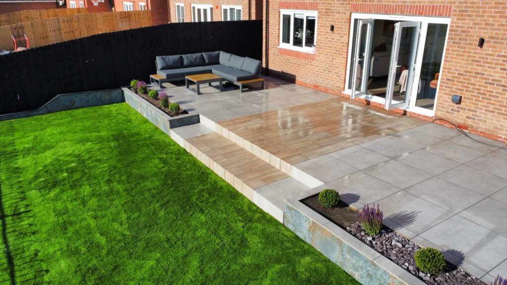 Porcelain terrace with wide steps down to a lawn