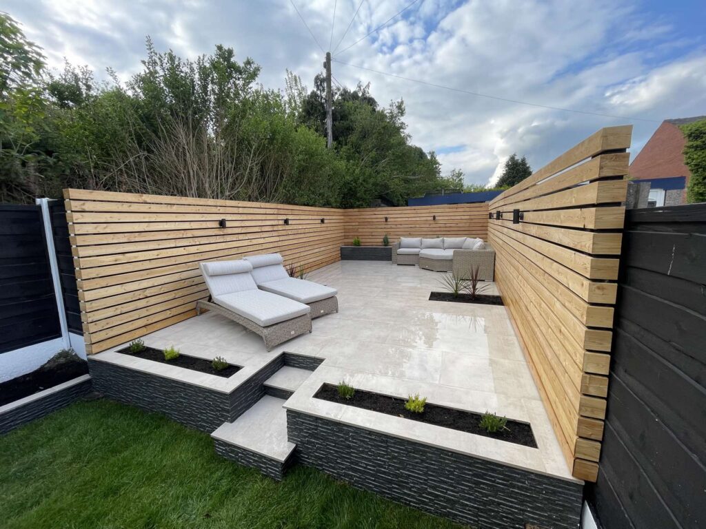 Raised porcelain terrace with slatted fencing and sun loungers