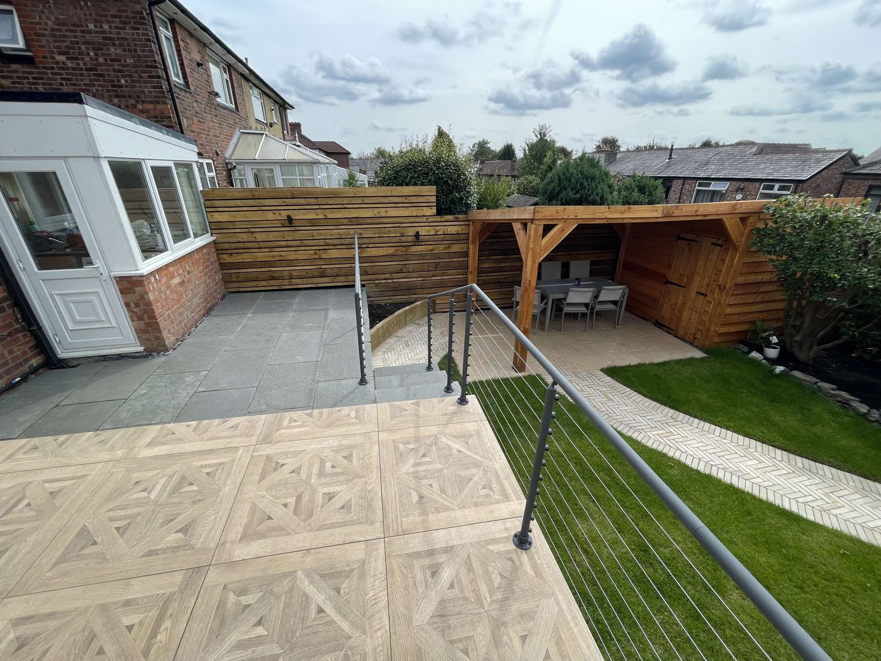 Raised porcelain terrace with glass balustrade and timber pergola
