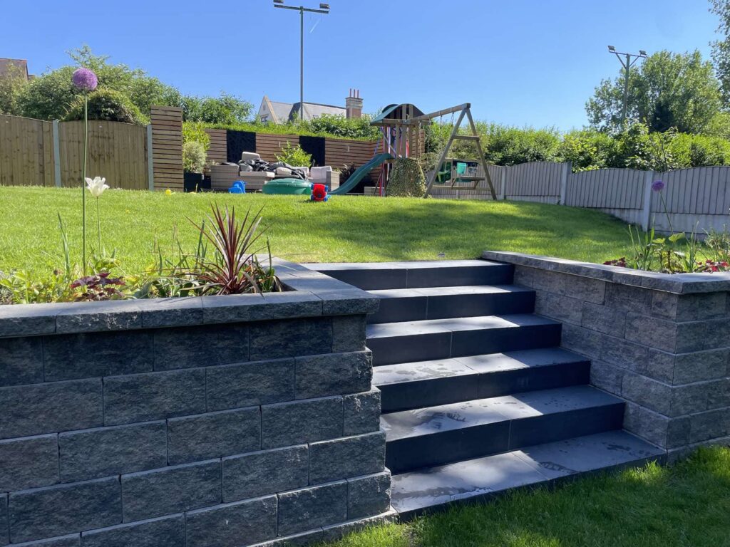 Block retaining wall with dark porcelain garden steps